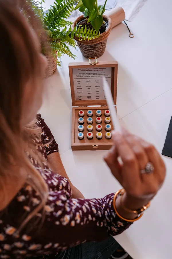 Juliette Garcia présentant un coffret d'huiles essentielles en cabinet de naturopathie à Clermont-Ferrand
